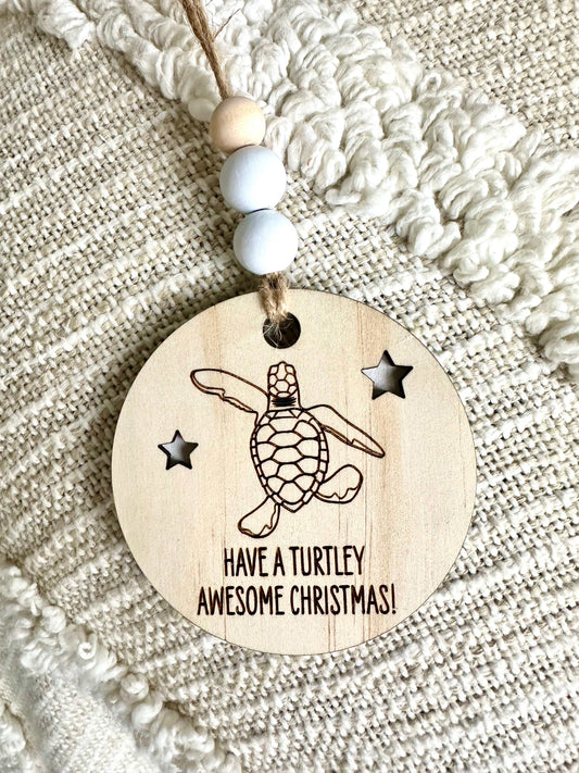 Wooden Christmas decoration with engraved baby turtle hatchling and stars, hanging ornament with beads and jute string.