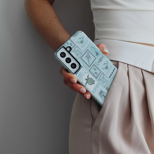 Samsung Phone Case with teal arches print and ocean-themed designs held in hand