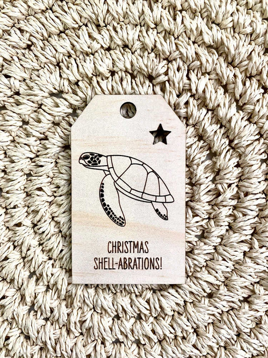 Wooden Christmas swing tag with green turtle design and festive "Christmas Shell-abrations" text