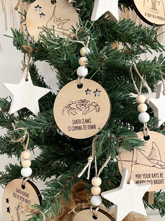 Wooden Christmas decoration crab ornament with "Santa Claws is coming to town" text hanging on tree