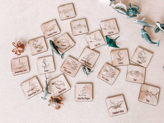 Wooden memory game with ocean animal illustrations and matching tiles on a beige surface