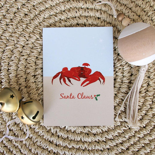 Christmas card with red crab illustration and Santa Claus text on woven background with bells and ornament