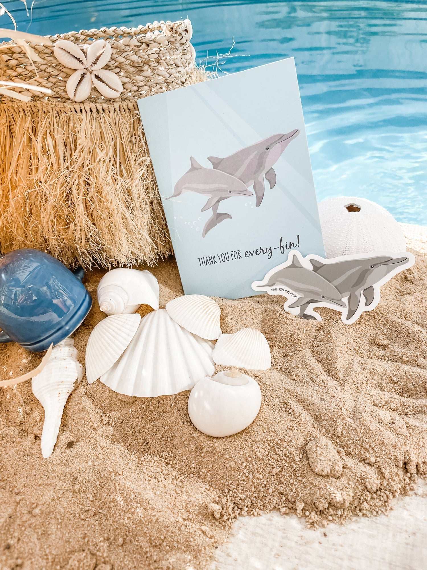 Bottlenose Dolphins sticker on beach sand with seashells and pool background