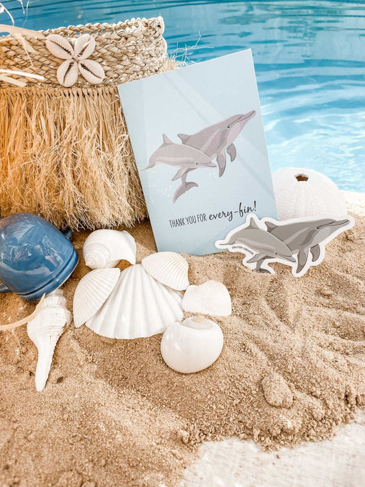 Bottlenose Dolphins sticker on beach sand with seashells and pool background